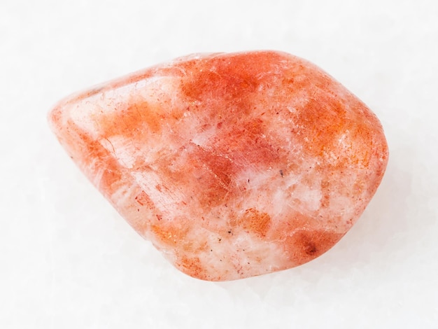 Tumbled sunstone heliolite gemstone on white