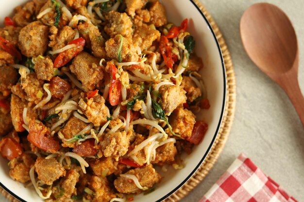 Tumis tauge oncom or vegetable stir fried bean sprouts on a white plate.