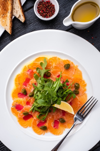 Tuna and salmon carpaccio with tarragon, capers and lemon.