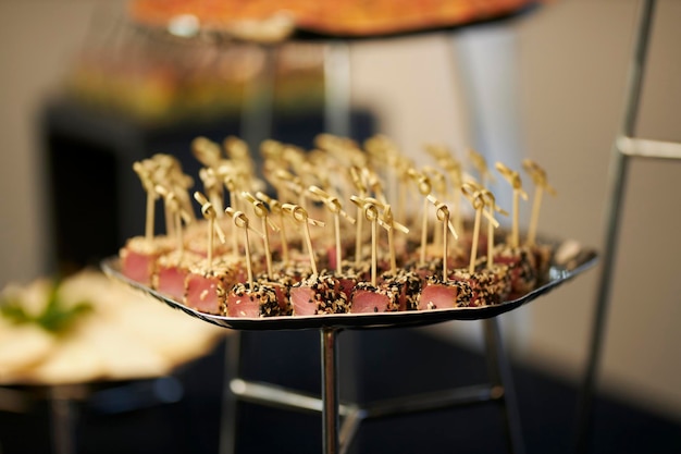 Tuna in sesame cut into pieces lies on a stand for snacks close-up. Catering. Tuna. soft focus