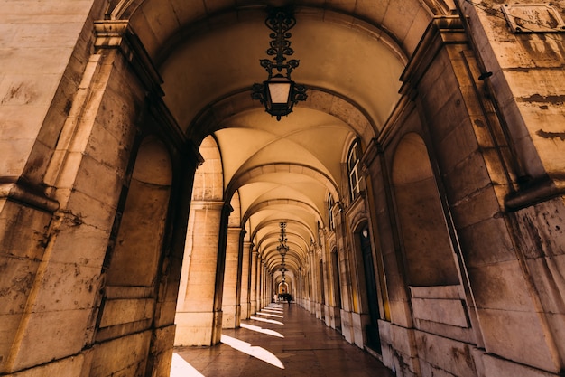 Tunnel of arches during a summer day with sunlight throw holes.