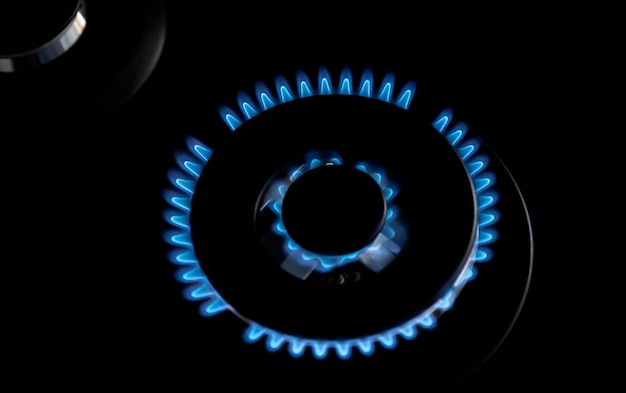 A turbo burner burns with a big blue flame on a gas stove in the kitchen View from above