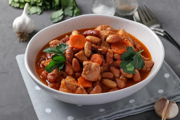 Turkey fillet with beans and carrots cooked in tomato sauce served in a white plate Healthy diet