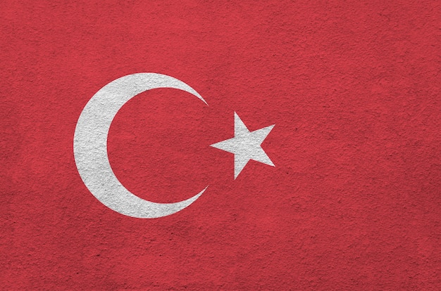 Turkey flag depicted in bright paint colors on old relief plastering wall.