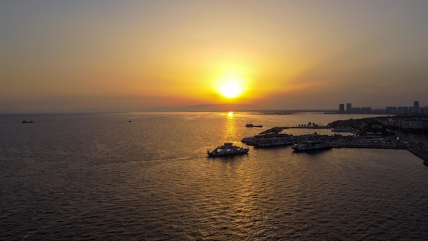 Turkey İzmir Karsiyaka Bostanli Ferry Pier sunset view aerial shot with drone, January 11, 2023.