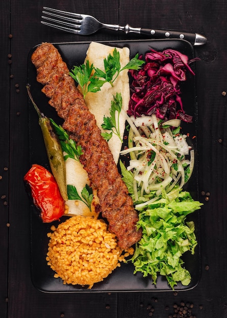 Photo turkish adana kebab serving on plate with vegetables bulgur and lavash bread