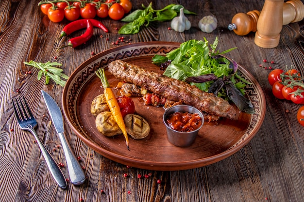 Turkish and Arabic Traditional Ramadan mix kebab plate, Kebab lamb and beef with baked vegetables, mushrooms and tomato sauce, close-up, horizontal photo