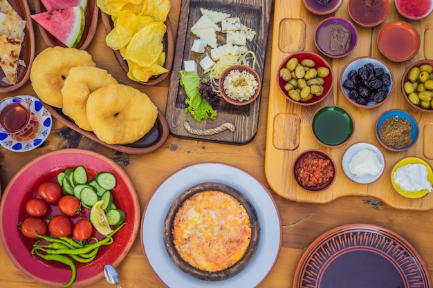 Turkish breakfast table pastries vegetables greens olives cheeses fried eggs spices jams honey tea