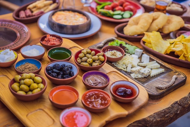 Turkish breakfast table pastries vegetables greens olives cheeses fried eggs spices jams honey tea