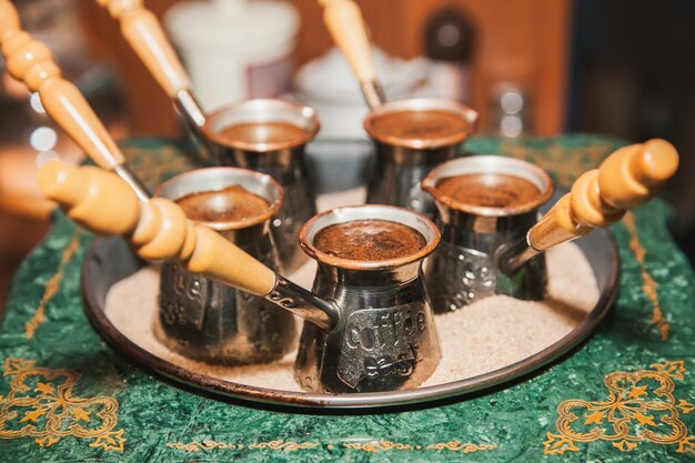 Photo turkish coffee brewed on sand in cezve. oriental, east coffee.