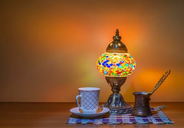 Turkish coffee in cezve Turk and a traditional old Arabic lamp