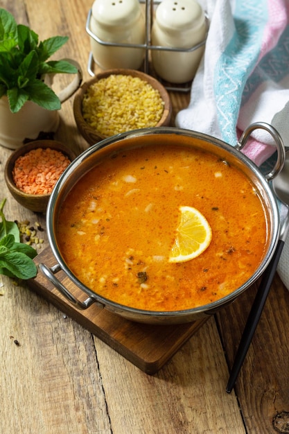 Turkish cuisine Traditional soup with rice lentils and mint on a rustic table Copy space