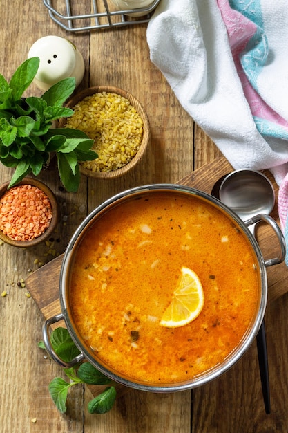 Turkish cuisine Traditional soup with rice lentils and mint on a rustic table Top view flat lay