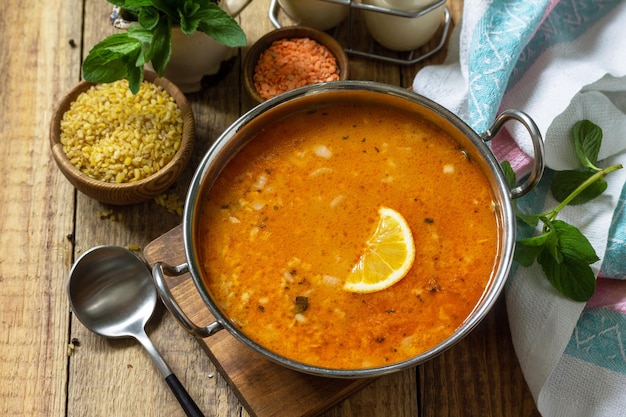 Turkish cuisine Traditional soup with rice lentils and mint on a rustic table