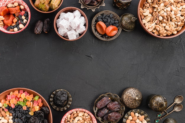 Turkish delight with dried fruits; nuts; lukum and baklava on black concrete background