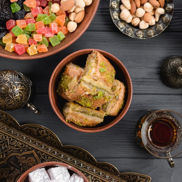 Turkish dessert baklava with dried fruits and nuts on wooden desk