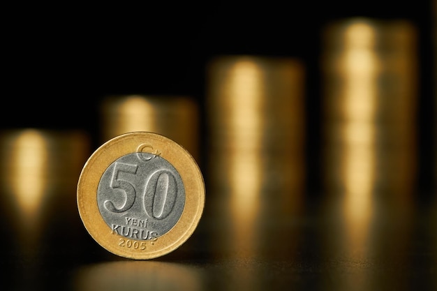 Turkish fifty lira coin on the background of stacks of coins