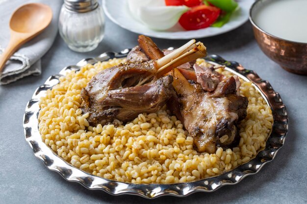 Turkish foods; lamb shank tandoori on bulgur wheat rice (Turkish name; bulgur bugday pilavi kuzu incik tandir)