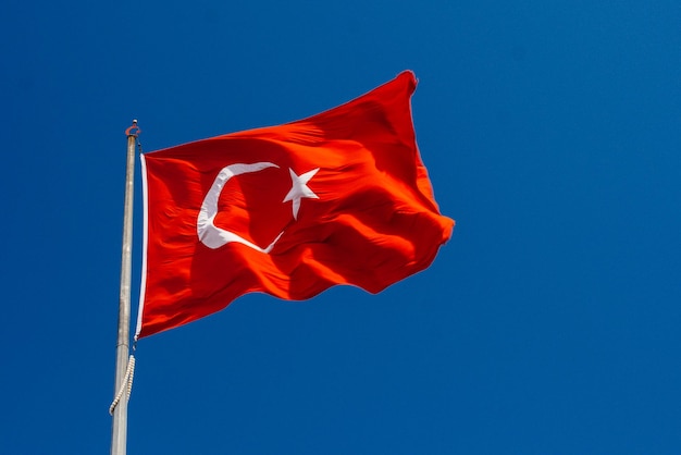 Turkish national flag with white star and moon in sky