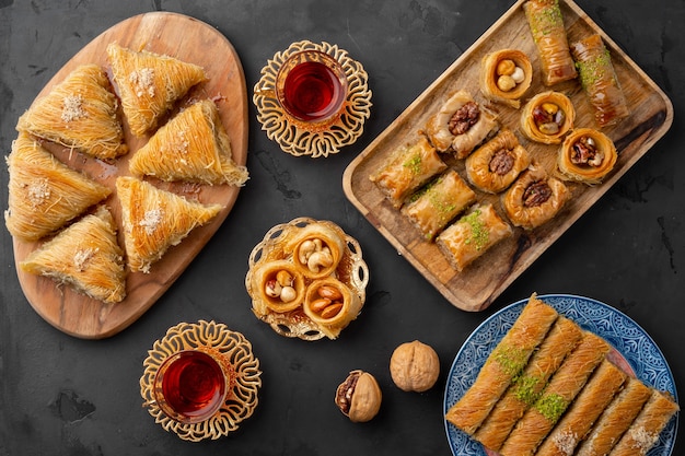 Turkish tea in traditional glasses baklava on black background