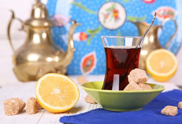 Turkish tea with cane sugar and lemon on a white table