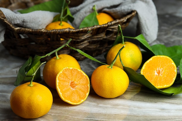 Turkish yellow green mandarines isolated on marble table with a basket of fresh ripe tangerines