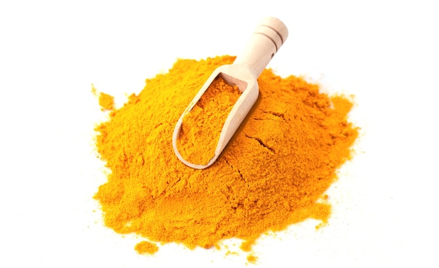 Turmeric or curcuma powder with wooden scoop isolated on white background