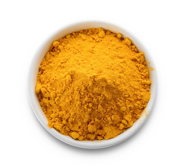 Turmeric powder in a bowl on white space