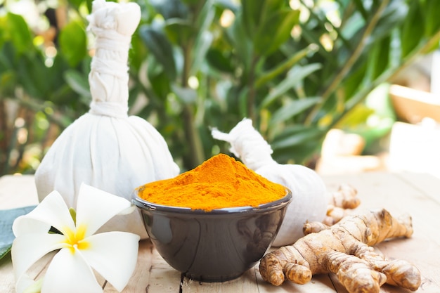 Turmeric powder in bowls on wooden table