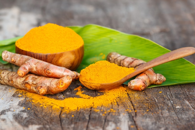 Turmeric powder in wooden bowls on wooden table