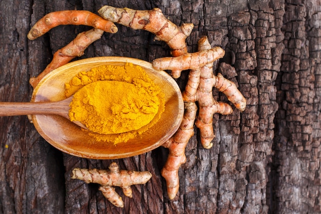 Turmeric powder in wooden bowls on wooden table