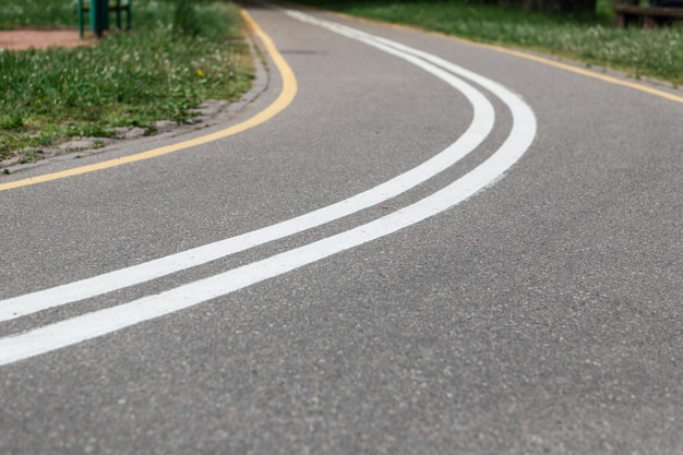 Turn of bike path in spring park. Empty road.