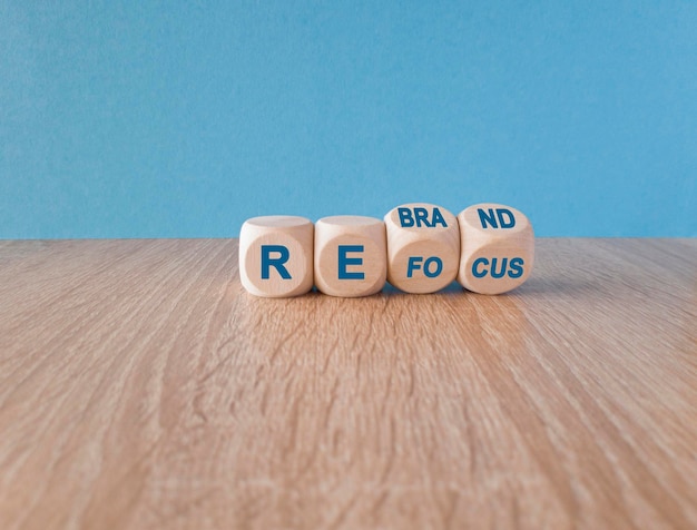 Photo turned wooden cubes and changed the blue word refocus to rebrand wooden table blue background