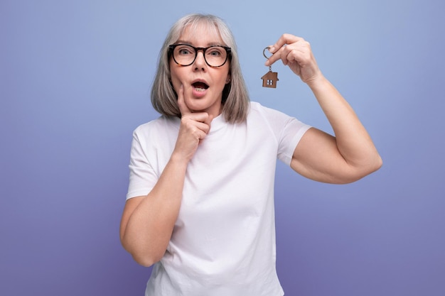 Turnkey property mature woman pensioner holding apartment keychain