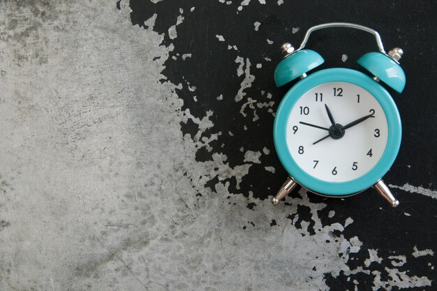 Turquoise alarm clock on black.