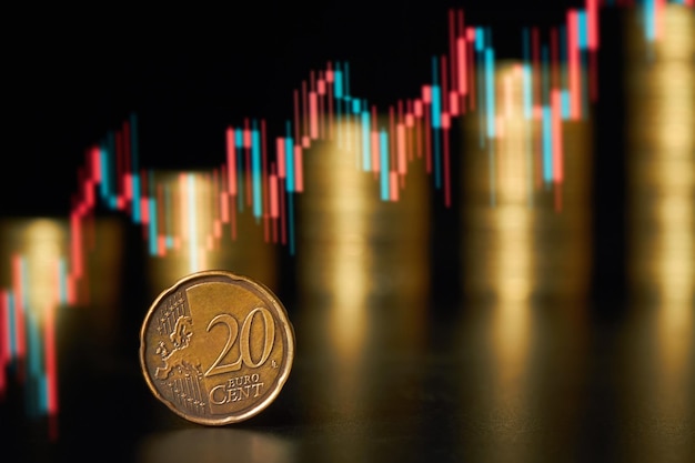 Twenty cent euro coin on the background of stacks of coins and Rising stock market chart