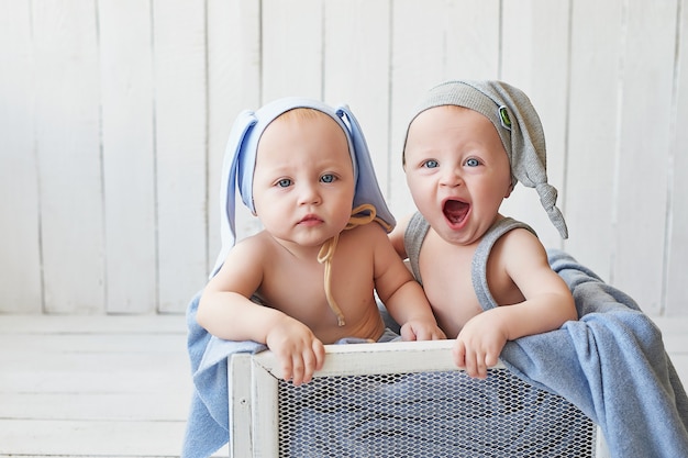 twin brothers with funny hats in the crib