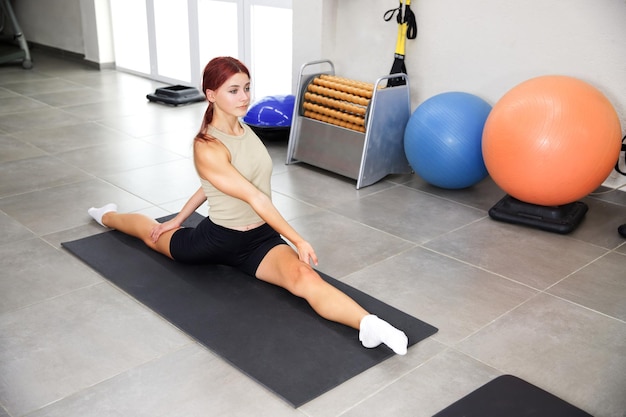 Twine stretching workout in the gym The girl is sitting in a twine Sport exercises