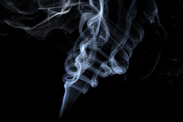 Twisted plumes of smoke smoke movement on a black background Abstract smoke lines