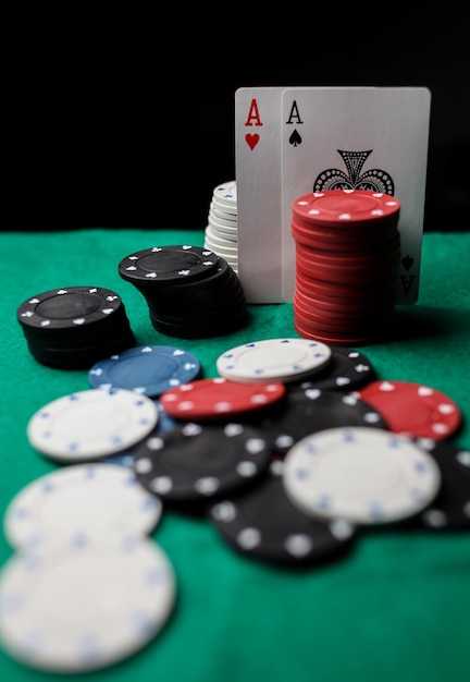 two aces in on the green gaming table. two playing cards and poker chips on a green casino table.