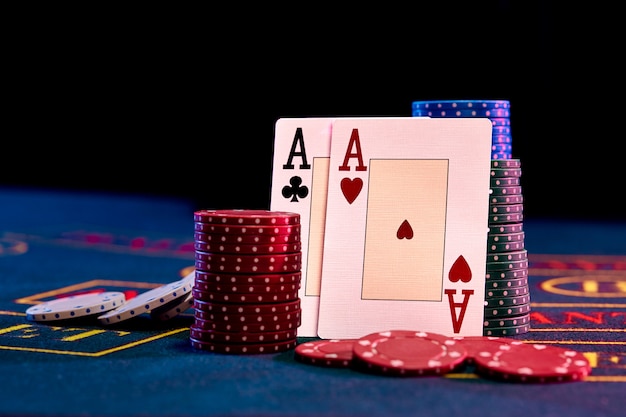 Two aces standing leaning on chips piles