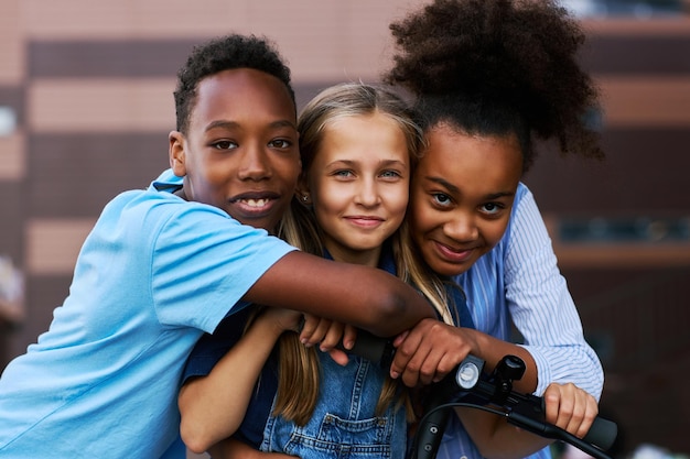 Two African American kids embracing their Caucasian friend