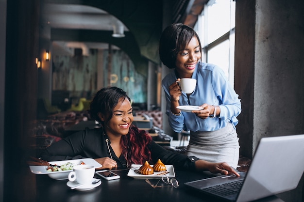 Two african american women with laptop and lunch