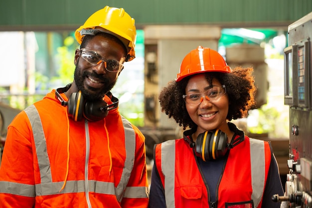 Two african worker smile and happy with their task in production line.Workplace operation.Two engineer on side maintenance machine.