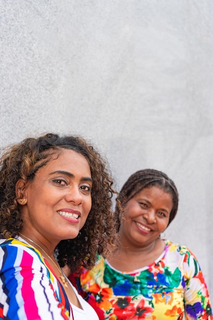 Two afro friends taking a selfie in front of a wall