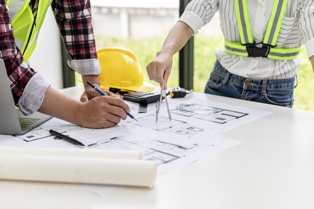 Two architect-engineers are consulting to modify the blueprints of the contracted house, they have a meeting to inspect the house designs before meeting with the client. Home design ideas.