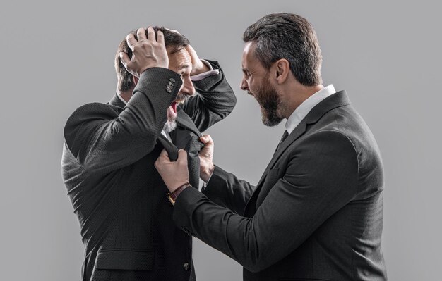 two arguing businessmen isolated on grey backdrop businessmen arguing in studio arguing businessmen shouting photo of businessmen arguing with anger