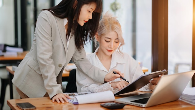 Two asia business working together with laptop on office desk in office room