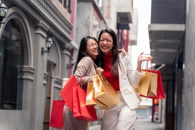 Two asian beautiful women with shopping bags in the city over mall background