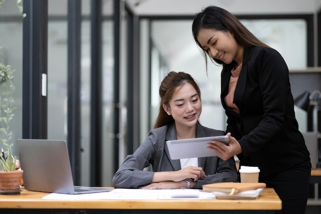 Two asian business woman work together to get the job done at the office